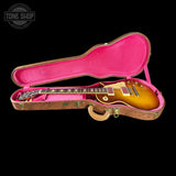 Electric guitar in a pink case with 'Tone Shop' logo in the corner.