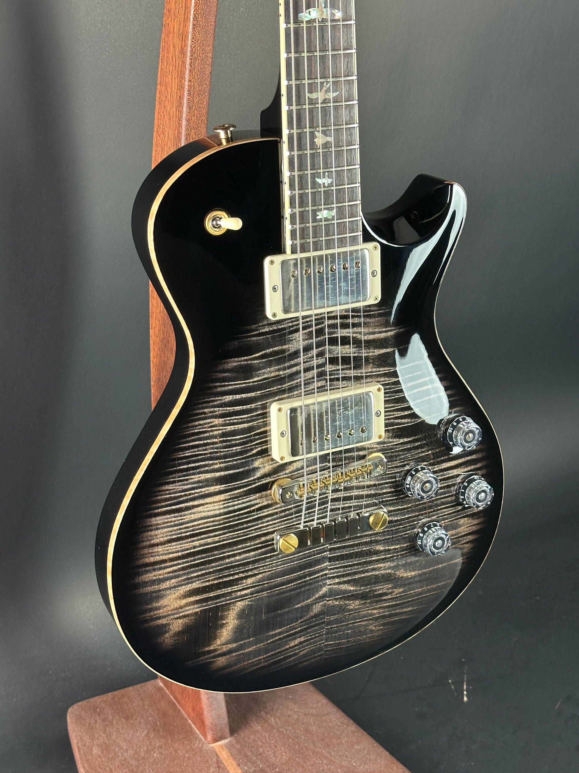 Electric guitar with a black and gold finish on a dark background