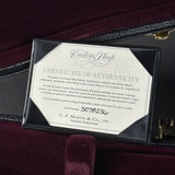 A black presentation box containing a white Certificate of Authenticity from CustomShop and C.F.