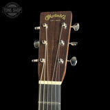 Martin & Co. acoustic guitar headstock featuring a dark brown wood finish, gold lettering, and six silver tuning pegs against a solid black background.