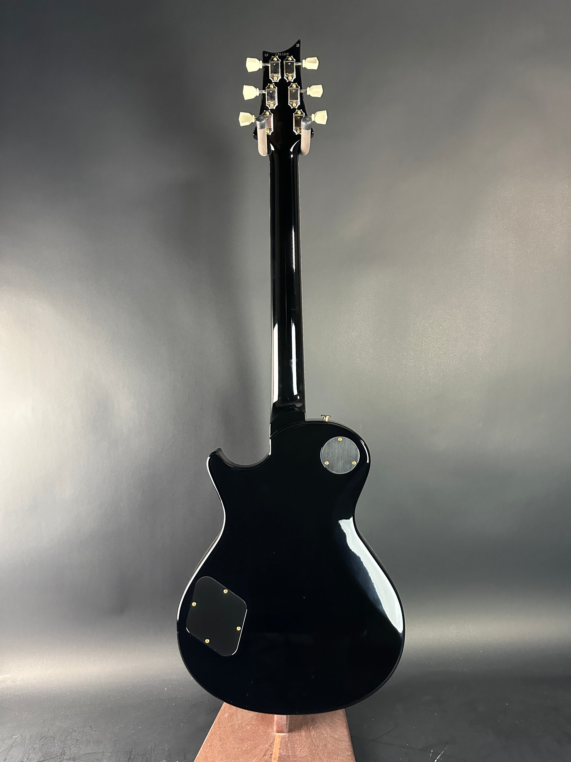 Black electric guitar on a gray background