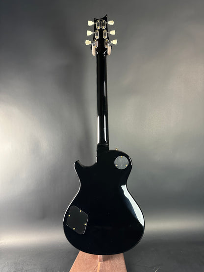 Black electric guitar on a gray background