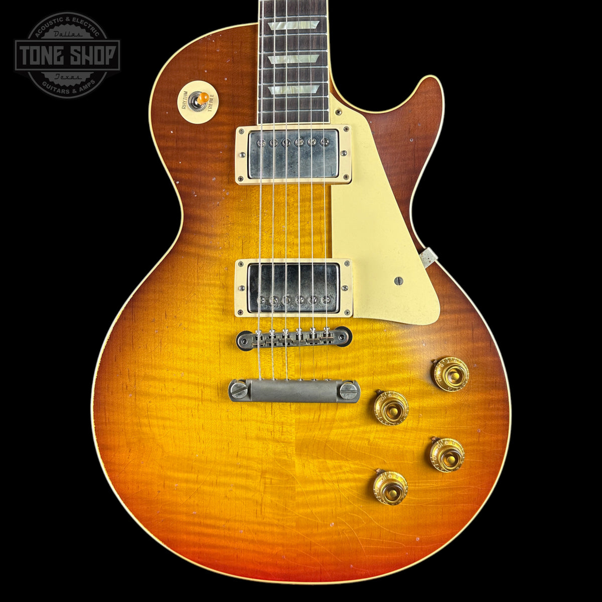 Electric guitar with a sunburst finish on a black background, featuring the Tone Shop logo.