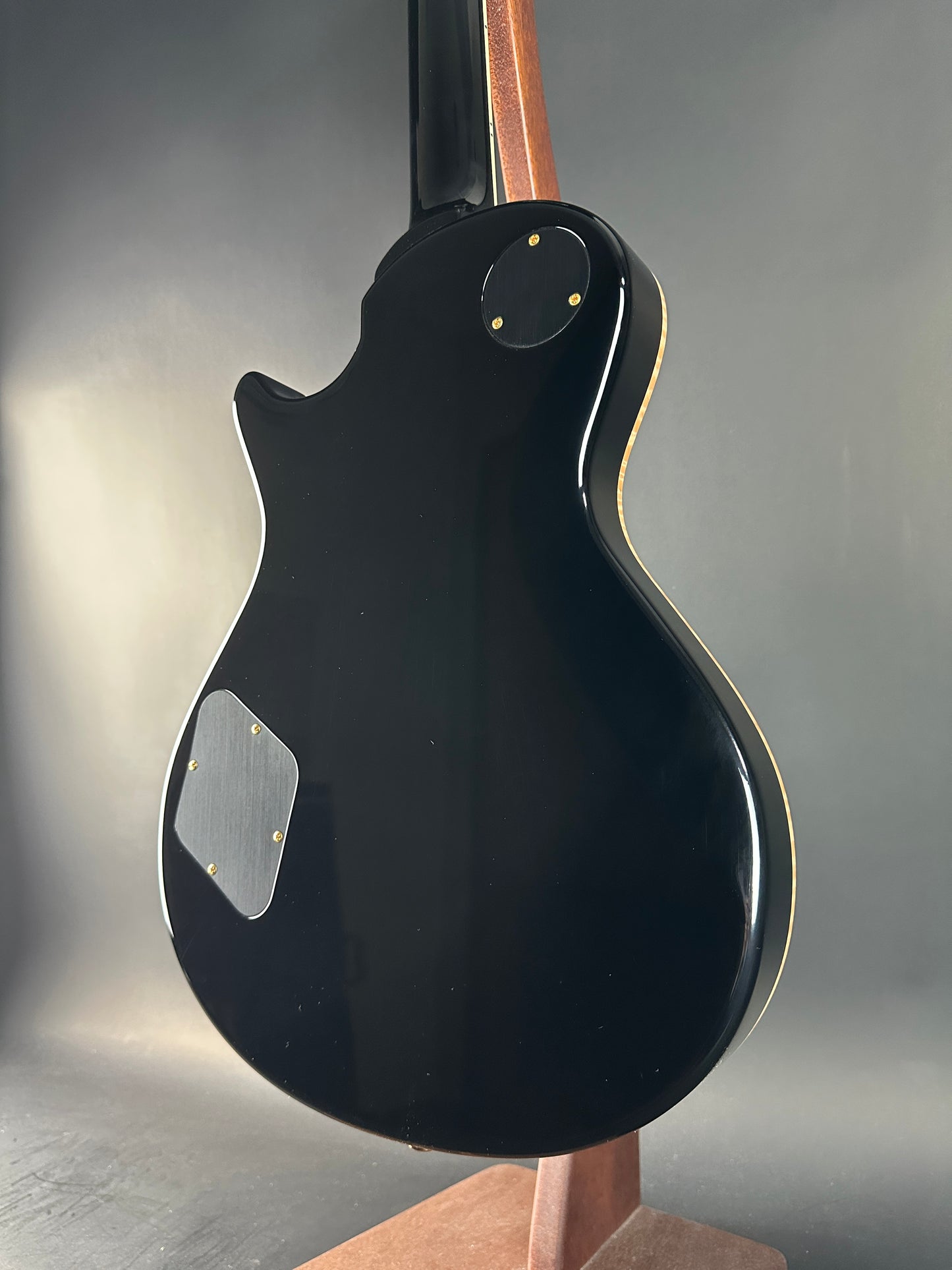 Close-up of a black electric guitar on a gray background