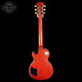 Back view of a red electric guitar on a black background with 'Tone Shop' logo.