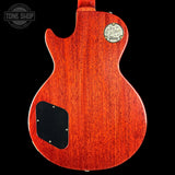 Back view of a red electric guitar with a Gibson logo on a black background