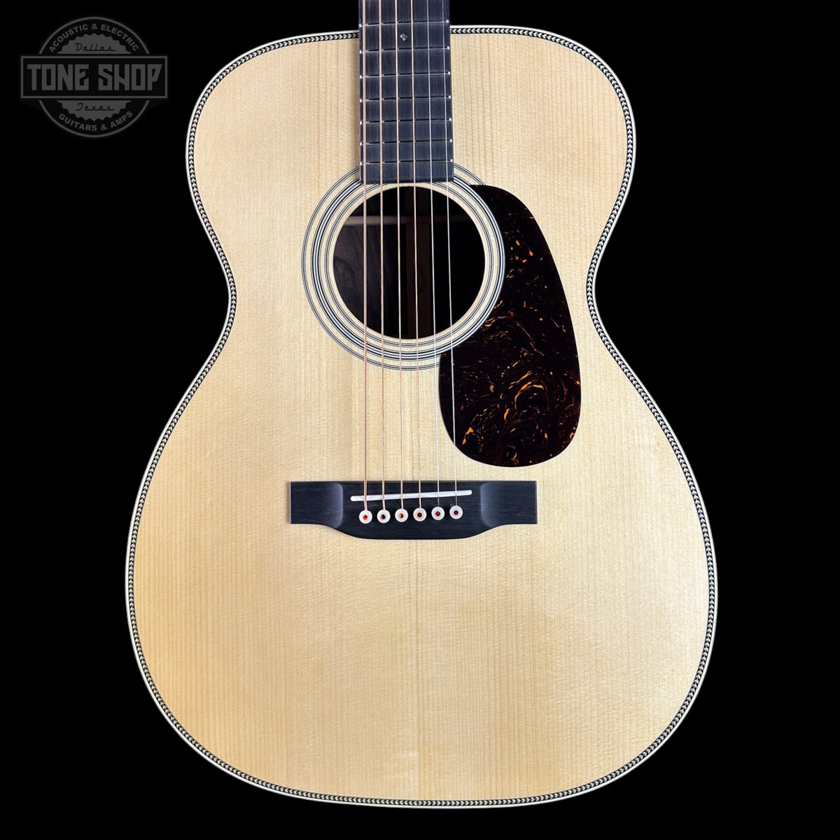 Acoustic guitar with a visible brand logo on a black background