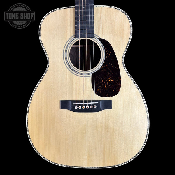 Acoustic guitar with a visible brand logo on a black background