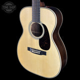 Acoustic guitar with a visible brand logo on a black background