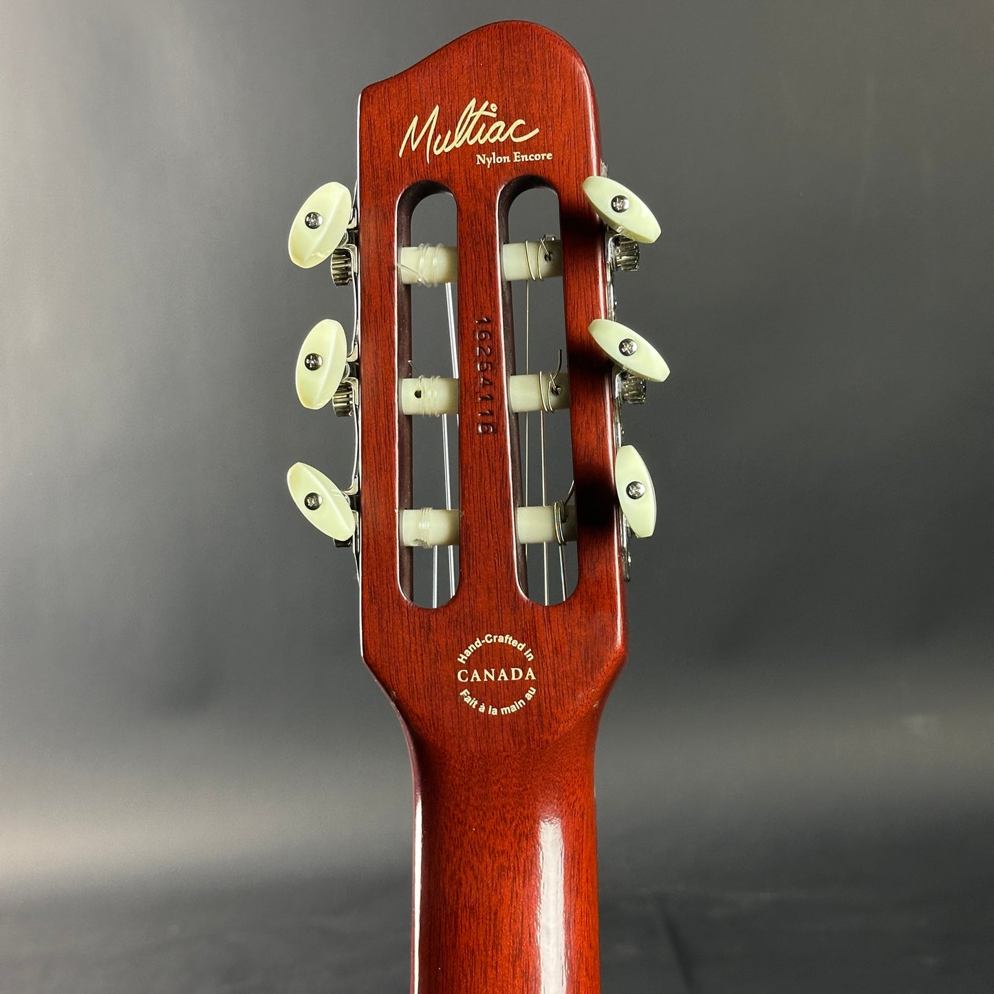 Close-up of a guitar headstock with 'Mellivac' branding on a gray background