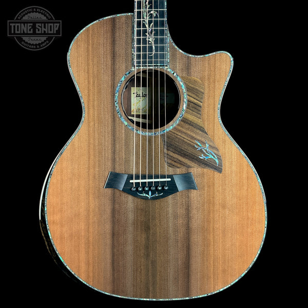 Acoustic guitar with a visible brand logo on a black background