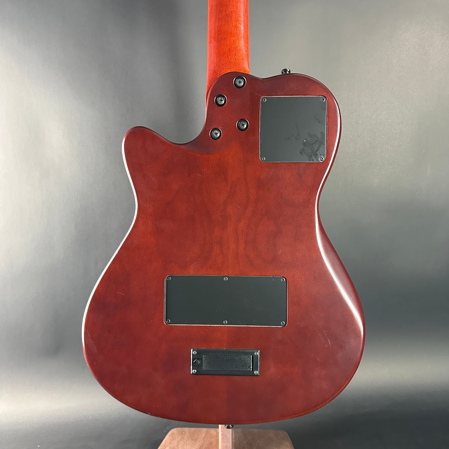 Back view of a red electric guitar on a gray background