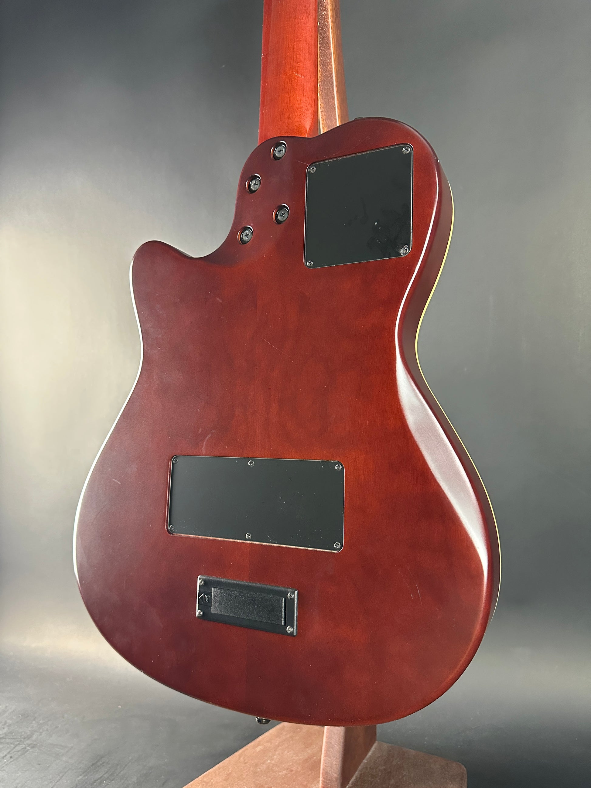 Close-up of a red electric guitar body with a dark gray background