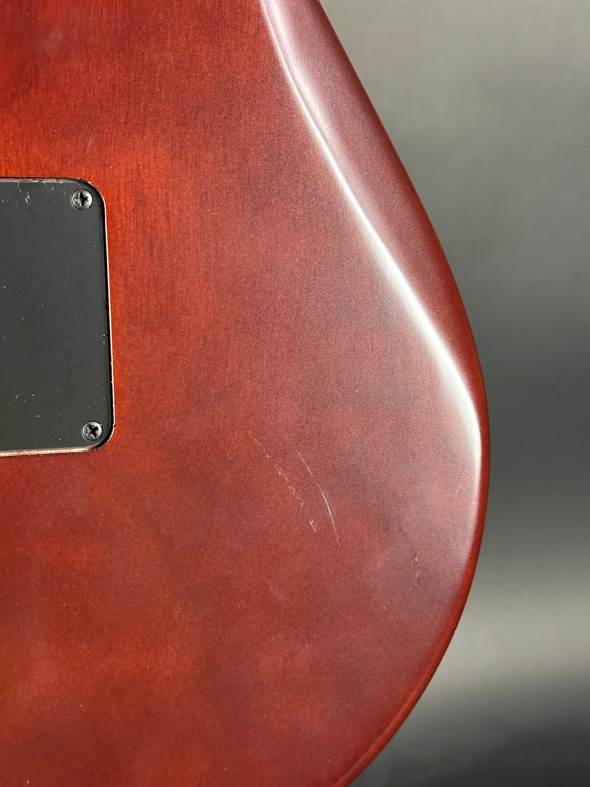 Close-up of a wooden guitar body with a dark brown finish.
