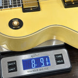 A close-up of a yellow electric guitar body resting on a digital scale displaying 8.91 lbs.