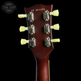Close-up of the headstock of a guitar, showing six cream-colored tuning pegs, metal tuning machines, and the model code CS 601329 printed on a dark reddish-brown wood background. A Tone Shop watermark is visible in the top left corner.
