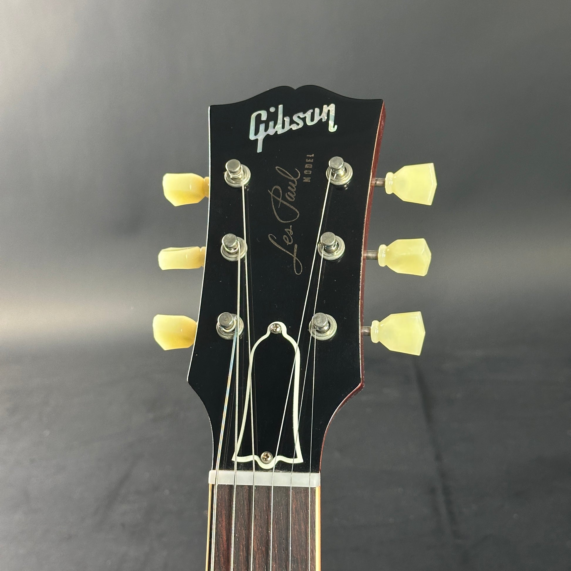 Gibson Les Paul guitar headstock on a gray background