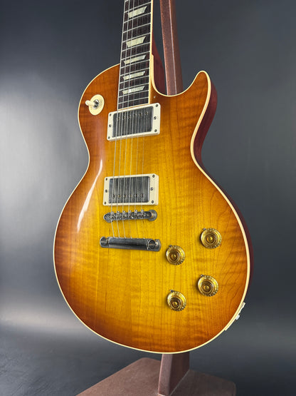 Close-up of a Les Paul guitar with a brown finish on a dark background