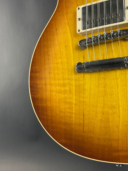Close-up of a guitar's body with a focus on the wood grain and hardware.