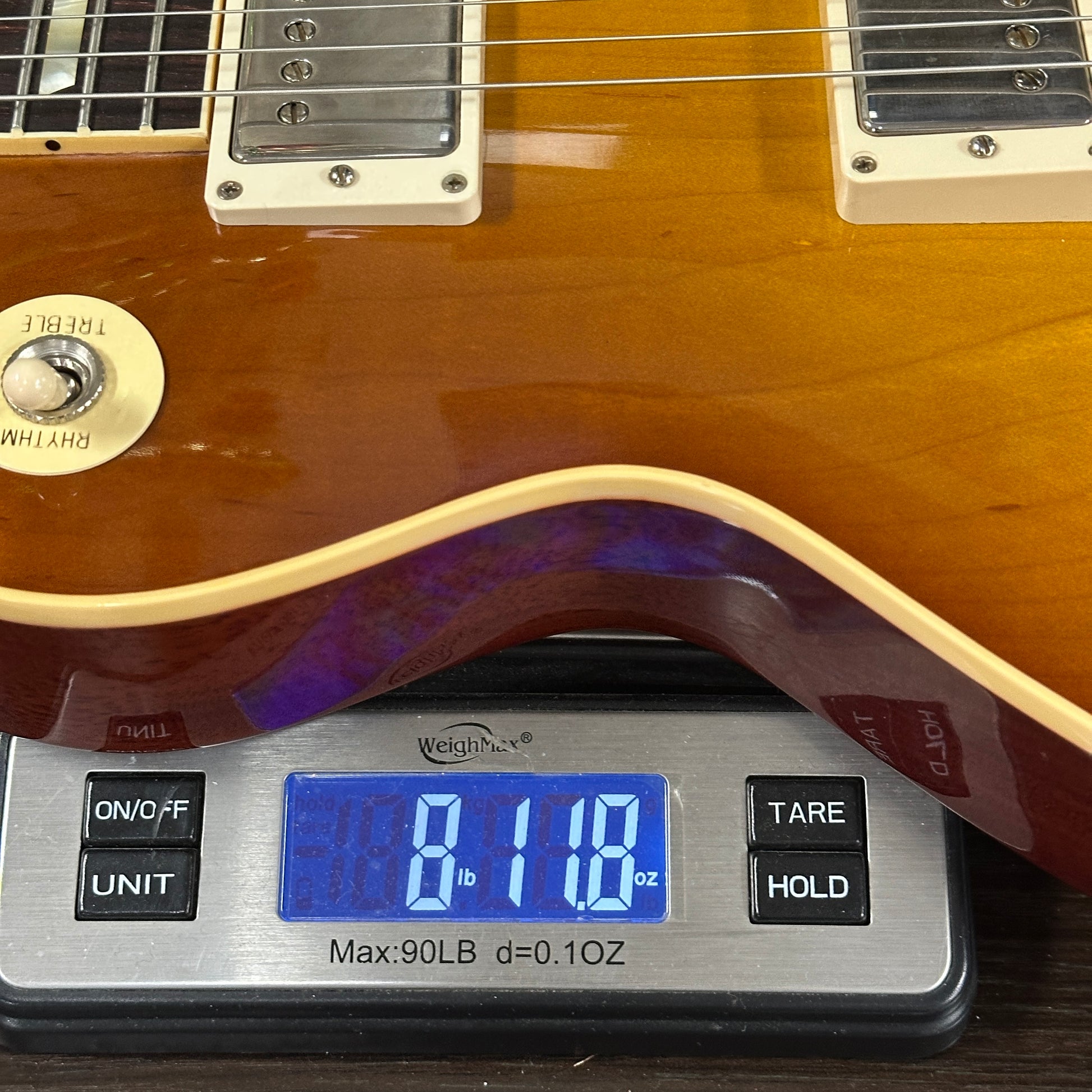 Guitar on a digital scale displaying weight