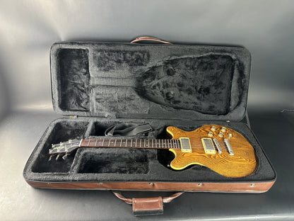 Gold electric guitar in a black case on a gray background