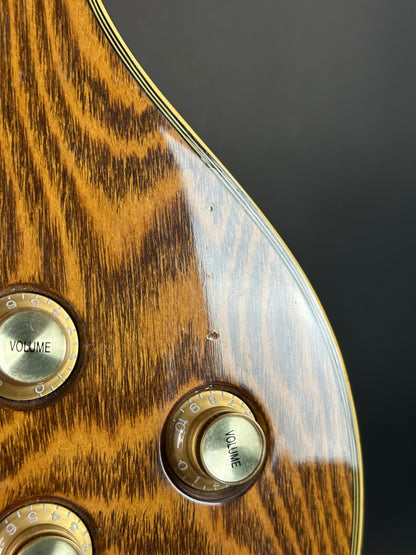 Close-up of a guitar's wood grain surface with volume knobs.