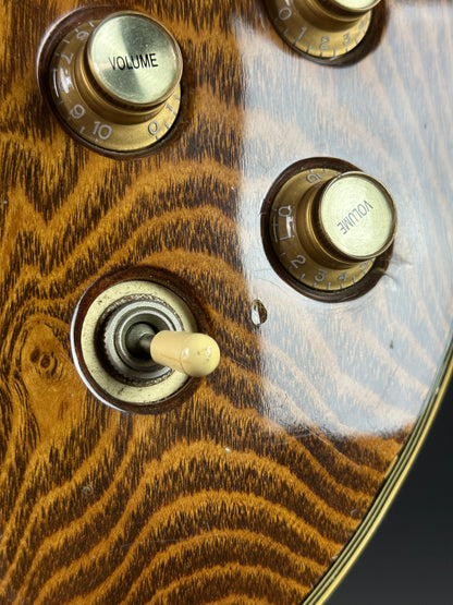 Close-up of a guitar control panel with volume knobs and a switch.