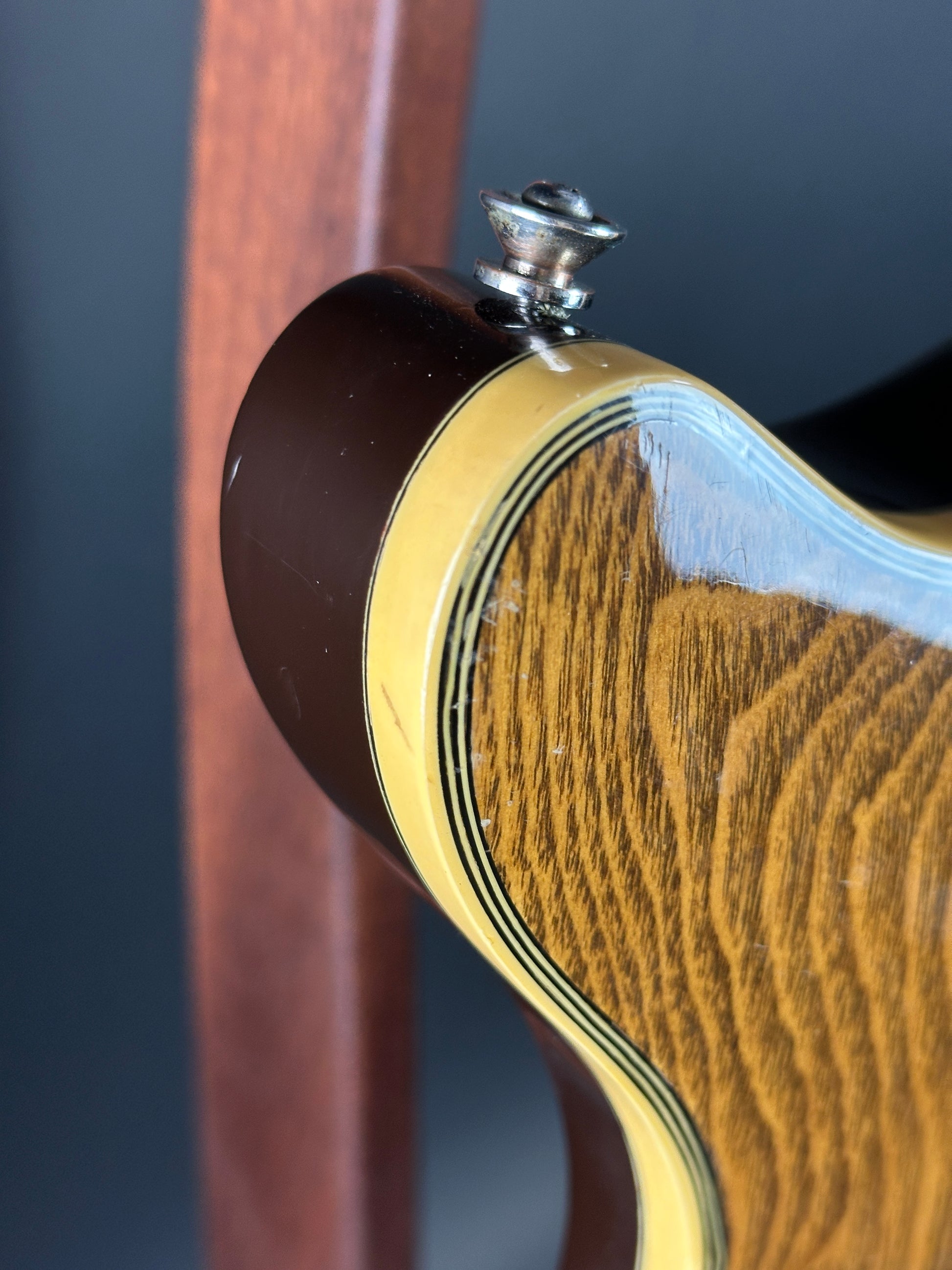 Close-up of a guitar's soundhole and wooden body on a dark background