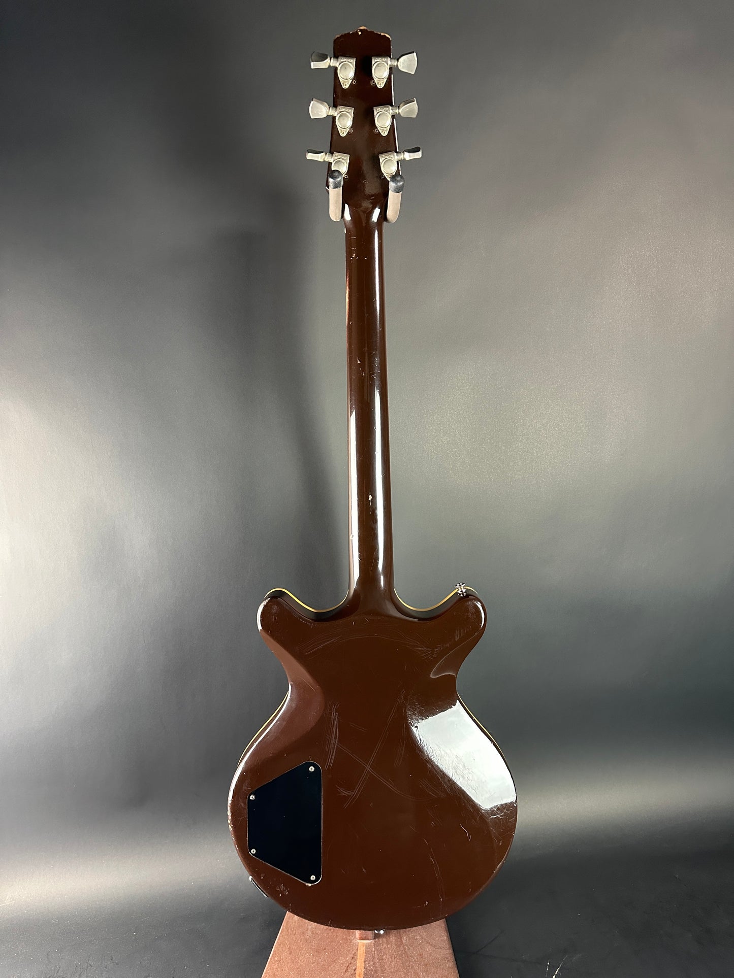 Brown electric guitar on a reflective gray surface
