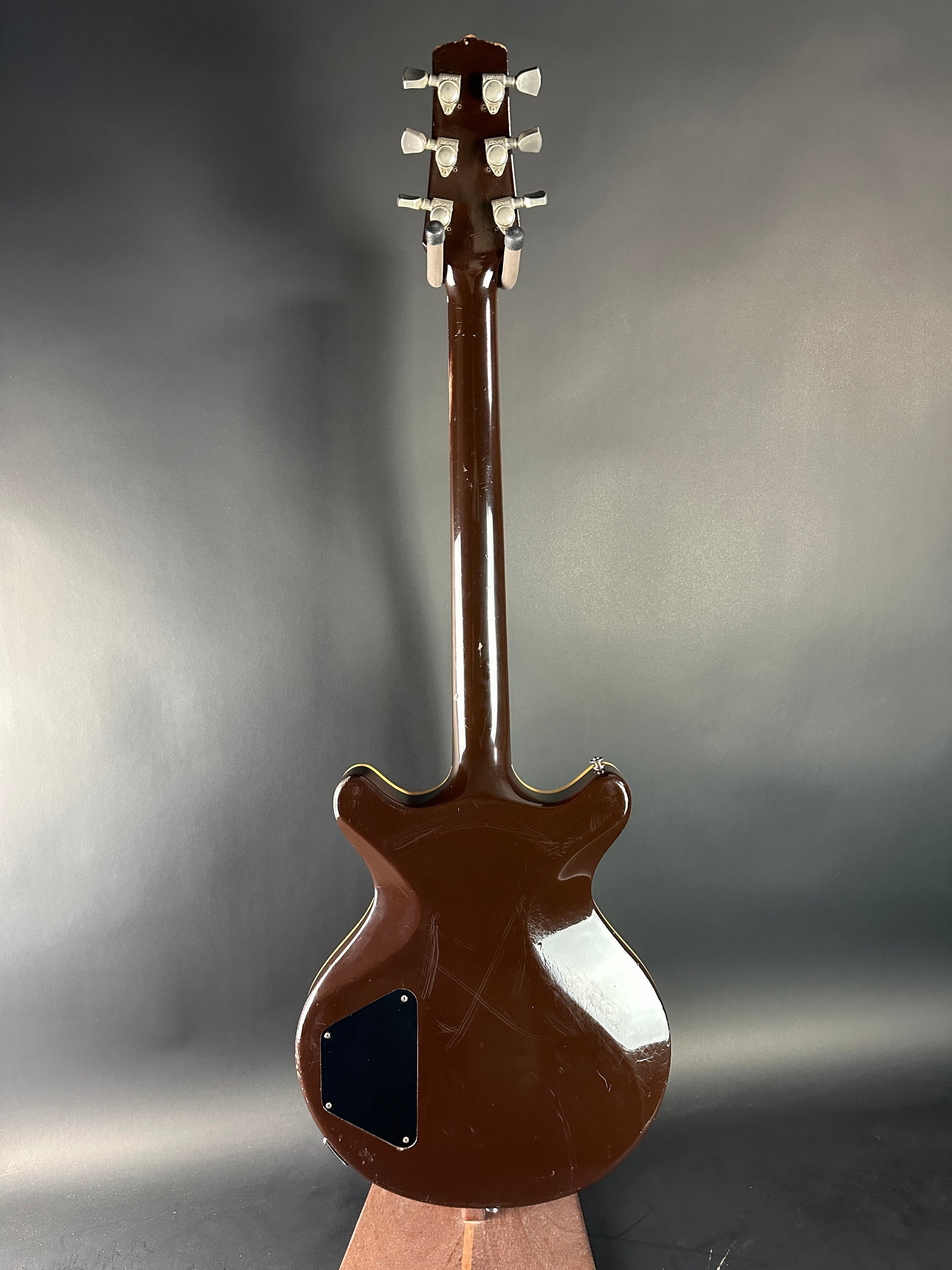 Brown electric guitar on a reflective gray surface