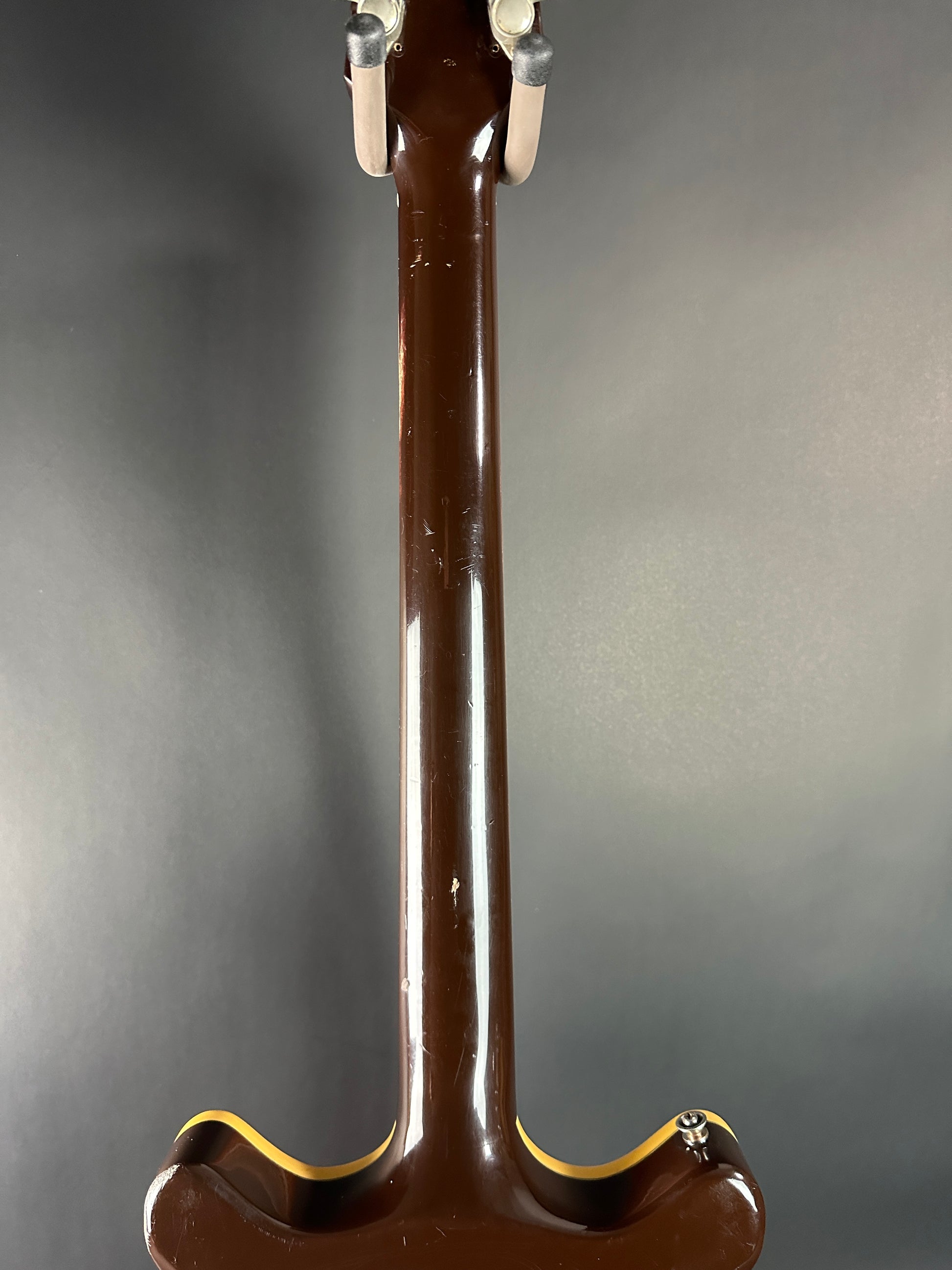 Close-up of a guitar neck on a gray background