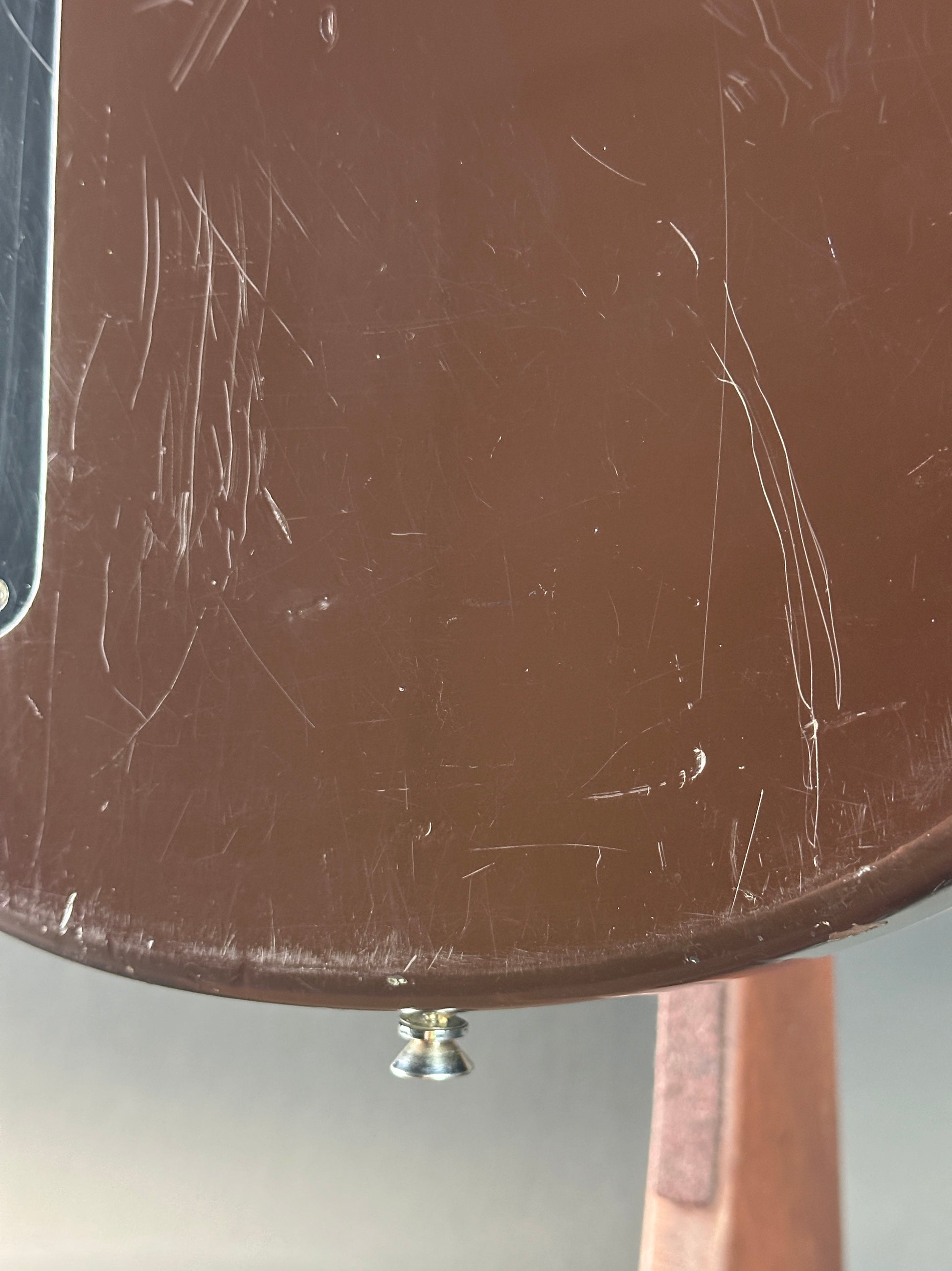 Scratched surface of a round object with a metallic button on a white background