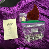 Guitar repair parts and tools on a purple surface with a warranty card.