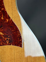 Close-up of a guitar's soundhole and body with a dark background