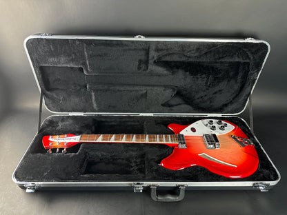 Red electric guitar in an open hard-shell case on a gray background
