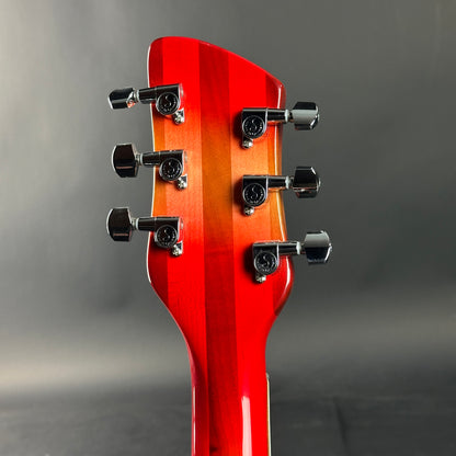 Close-up of a red electric guitar headstock on a gray background