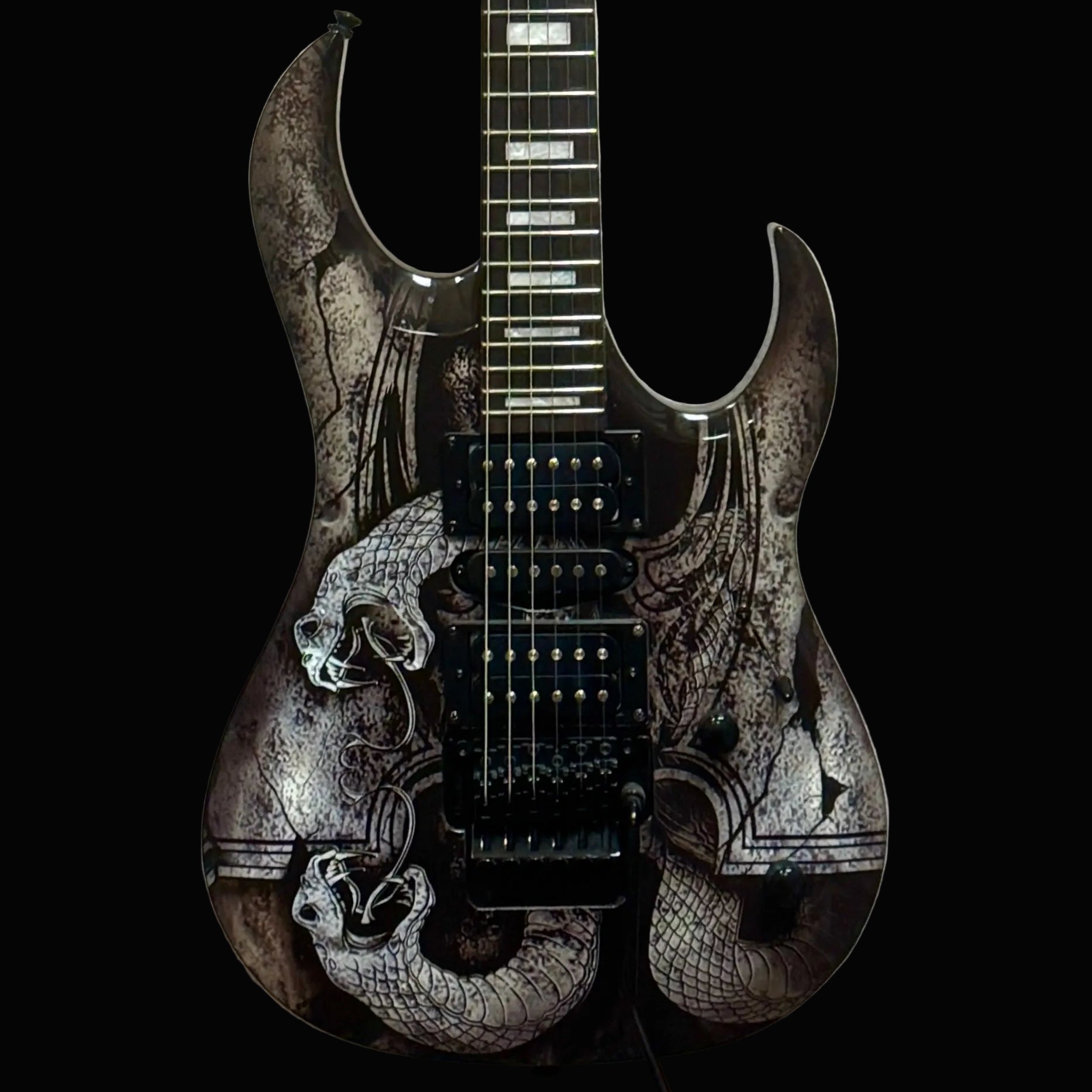 Black and white electric guitar with intricate designs on a light gray background