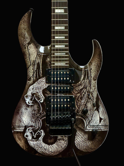 Guitar with intricate designs on a beige wall