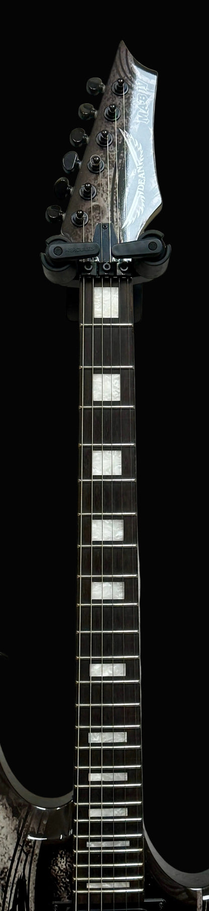 Black electric guitar with a white pickguard on a gray background