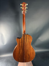 Wooden acoustic guitar on a reflective gray surface