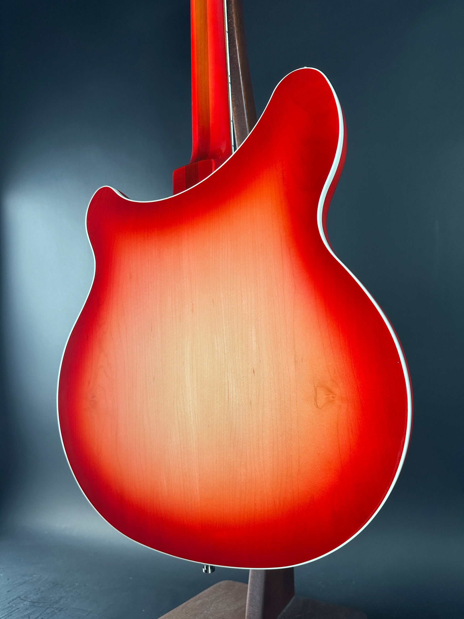 Close-up of a red electric guitar body on a dark background