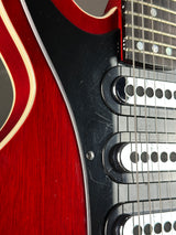 Close-up of a red electric guitar's neck and fretboard