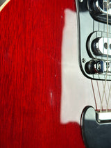 Close-up of a red electric guitar with a focus on the neck and headstock.