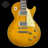 A classic electric guitar with a natural sunburst finish, featuring a cream pickguard, dual humbucker pickups, and gold-toned hardware, shown against a solid black background.