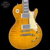 A classic electric guitar with a natural flamed maple top, cream pickguard, and gold hardware, shown against a solid black background. A 'Tone Shop' watermark is visible in the top-left corner.