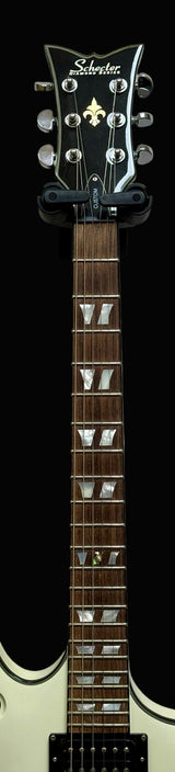 Electric guitar with a white body and black pickguard on a gray background