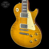 A classic electric guitar with a natural maple wood finish, cream pickguard, and gold hardware, shown against a solid black background with a Tone Shop watermark in the top-left corner.