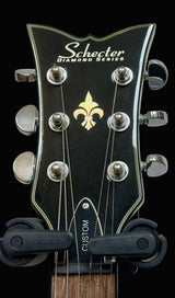 Close-up of a Schecter Diamond Series guitar headstock with logo.