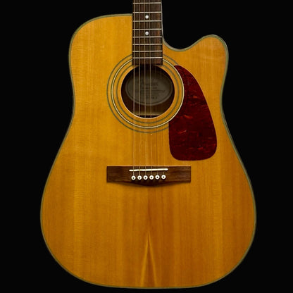 Acoustic guitar with a cutaway on a light gray background