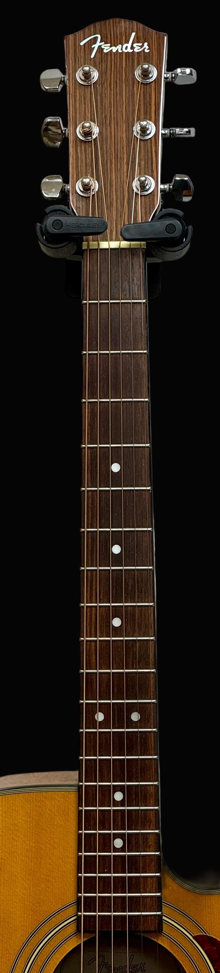 Fender acoustic guitar neck against a white wall